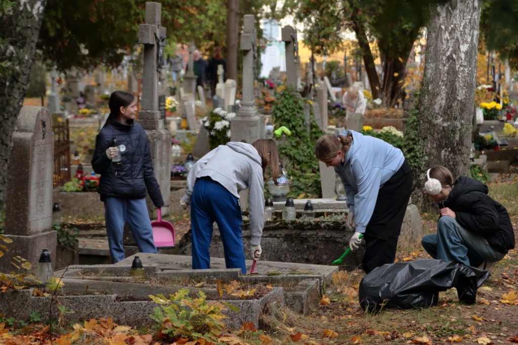 uczniowie sprzątają cmentarz