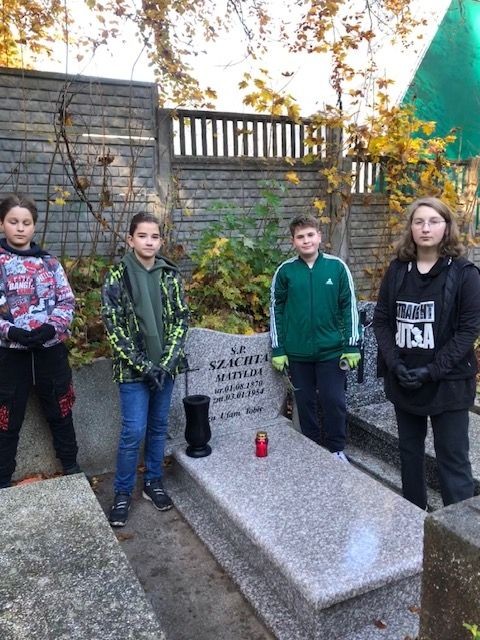 grupa uczniów przy nagrobku na starym cmentarzu w Wejherowie