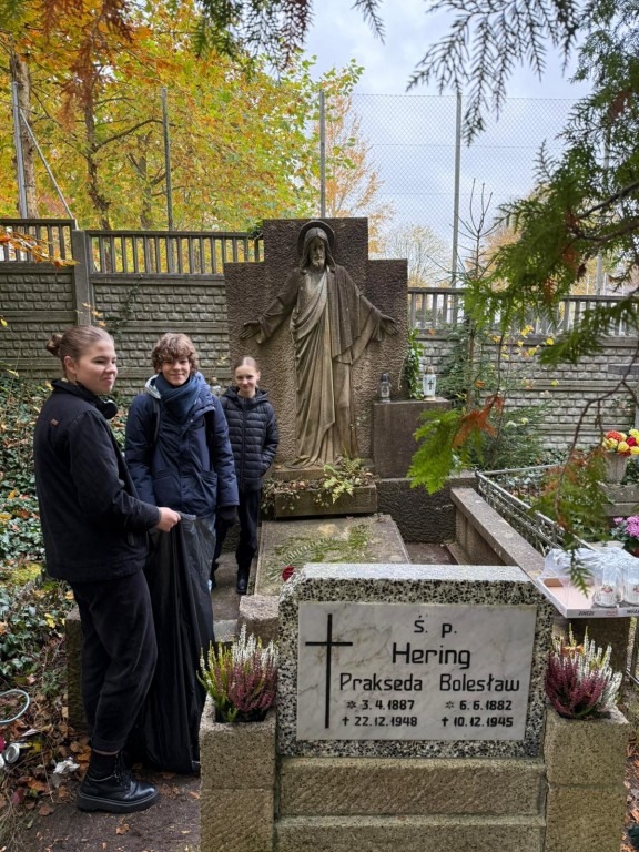 uczniowie porządkują groby na cmentarzu