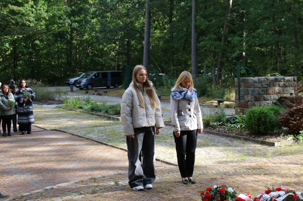 delegacja ze szkoły podstawowej składa wieniec przed pomnikiem