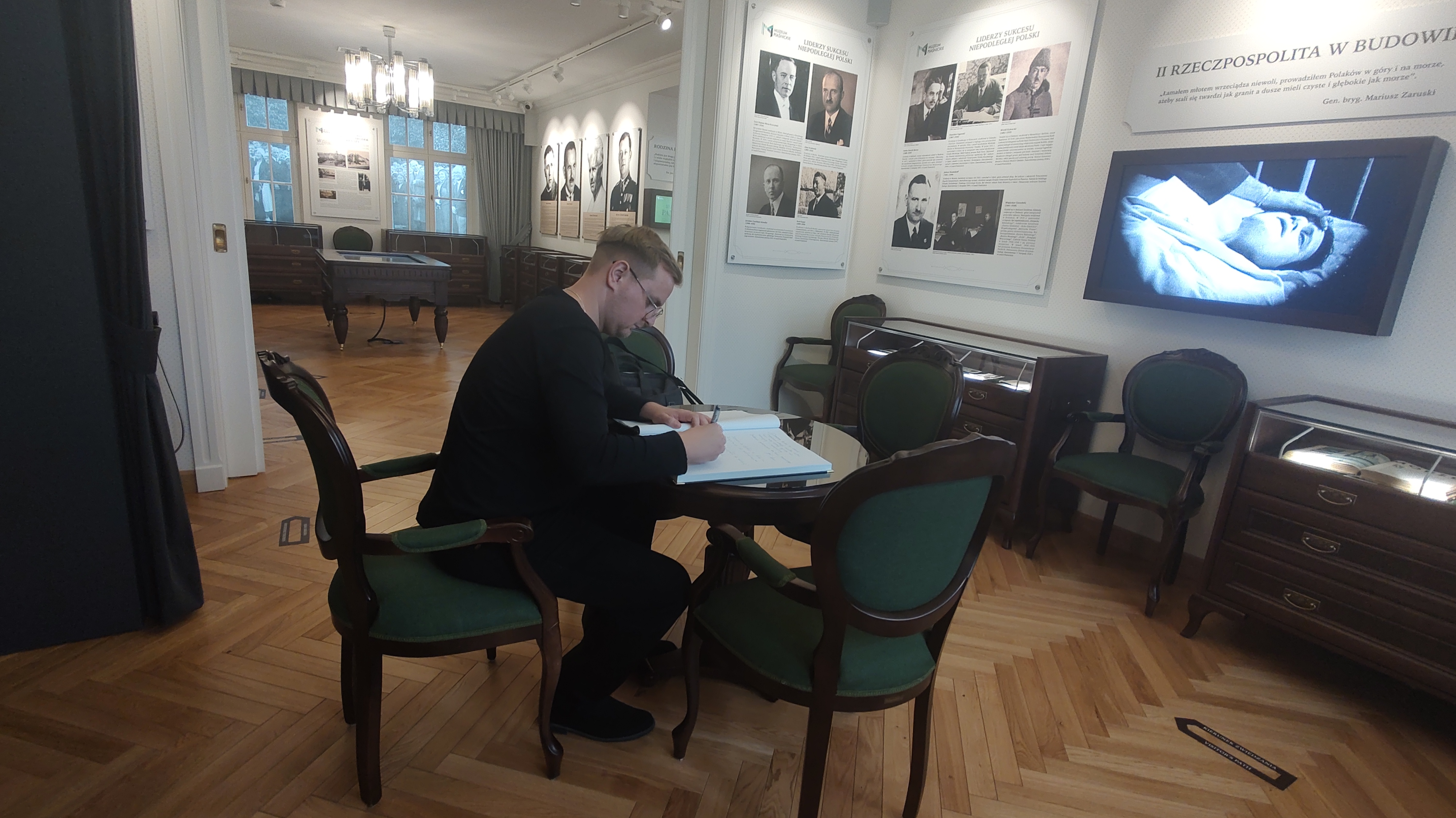 Adam Deisner wpisuje się do księgi gości w Muzeum Piaśnickim