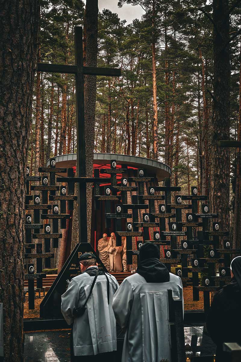 People pray in front of the mass grave of the victims of the Piaśnica massacre