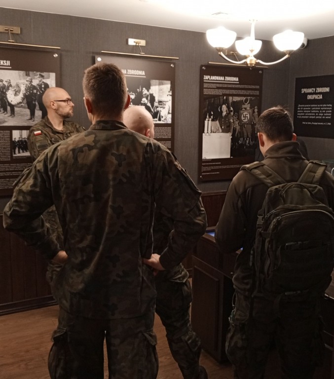 grupa żołnierzy ogląda wystawę w Muzeum Piaśnickim