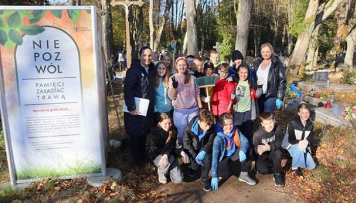 grupa młodzieży pozuje do zdjęcia na wejherowskim cmentarzu