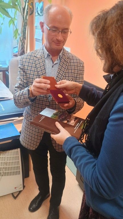 kierownik Muzeum Piaśnickiego otrzymuje pamiątkową monetę od dyrektora szkoły w Starzynie
