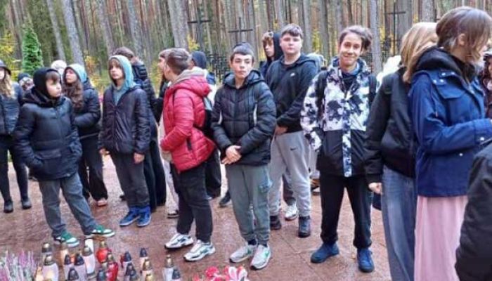 uczniowie zapalają znicze pod pomnikiem w Lesie Piaśnickim