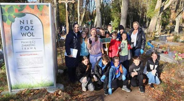 grupa młodzieży pozuje do zdjęcia na wejherowskim cmentarzu