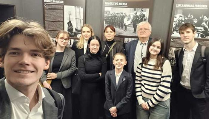 uczniowie liceum pozują z pracownikiem Muzeum Piaśnickiego