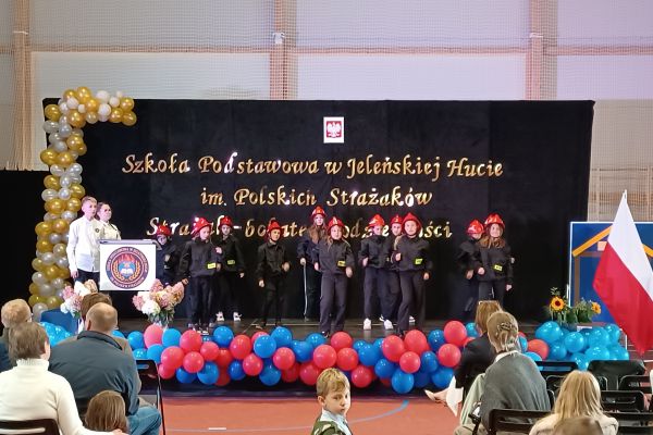 grupa dzieci przebrana za strażaków odgrywa wystąpienie podczas uroczystości