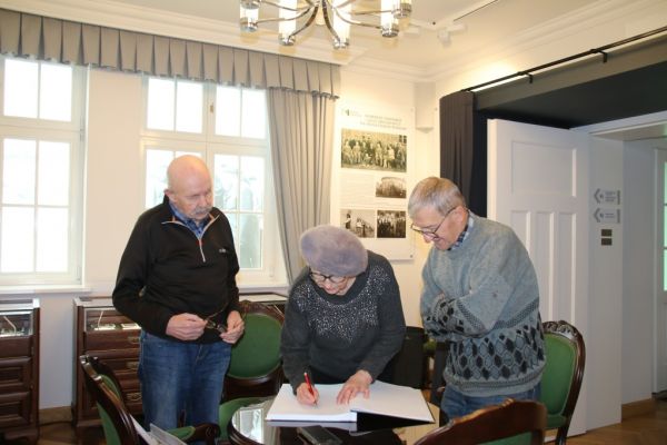 Państwo Socha wpisują się do księgi gości w Muzeum Piaśnickim