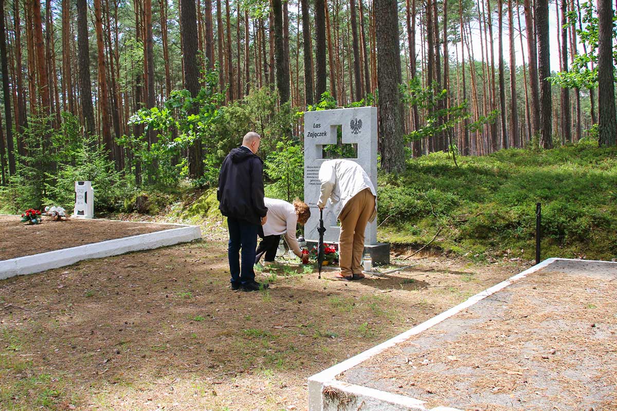 pracownicy Muzeum Piaśnickiego składają znicze w Lesie Zajączek